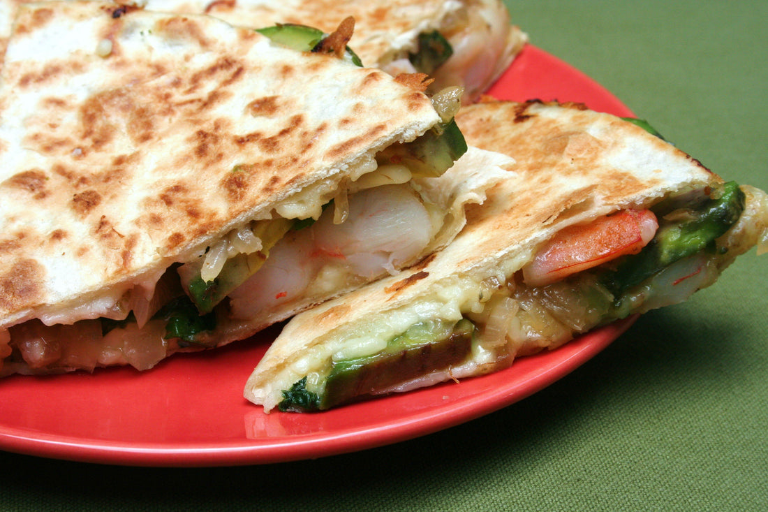 Avocado shrimp quesadillas on a red plate