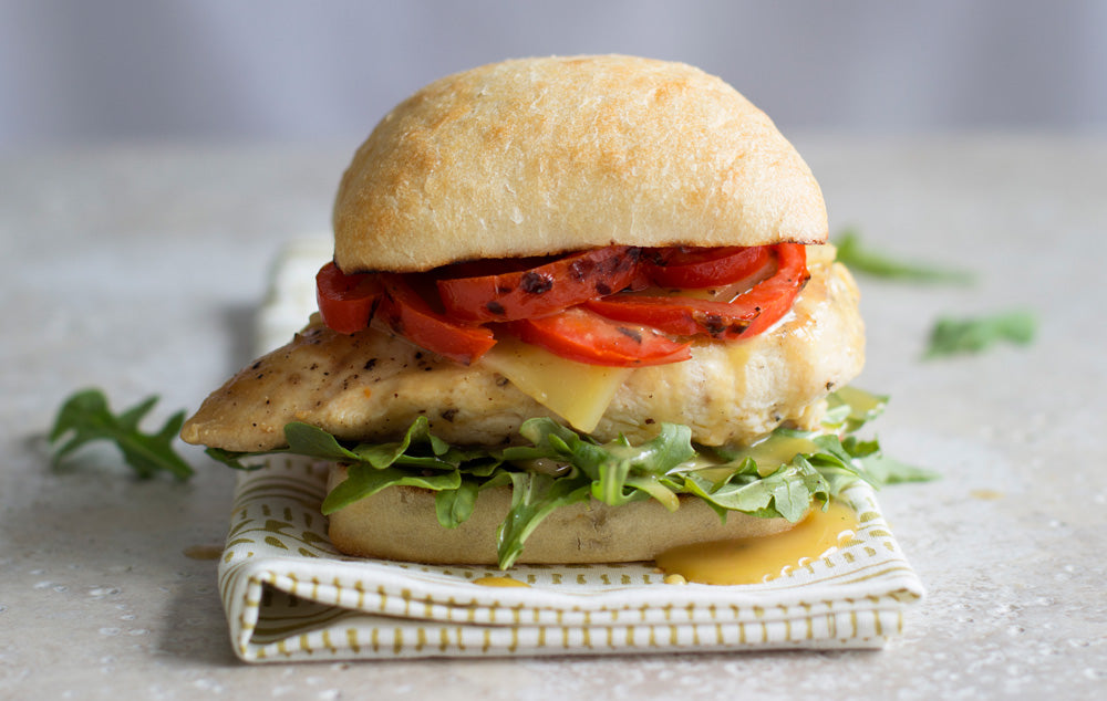 Chicken burger resting on a napkin on a white counter