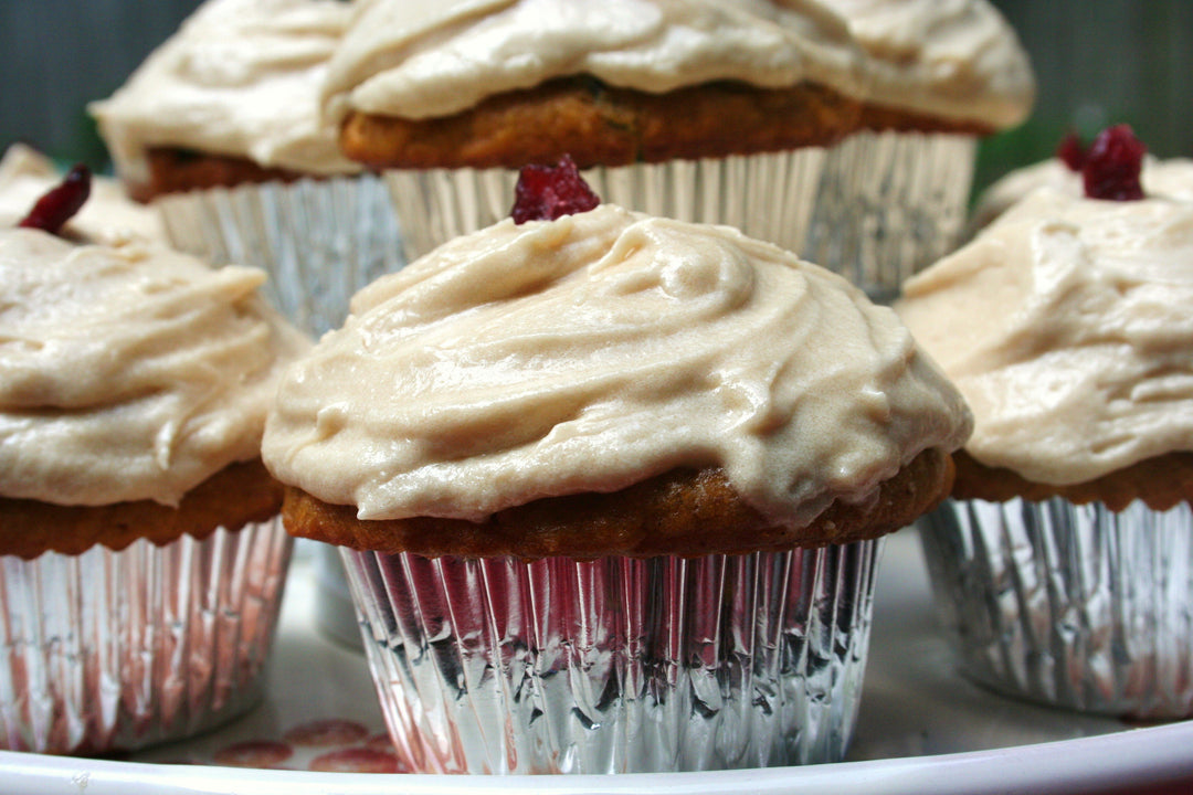 Closeup of pumpkin cranberry cupcakes on a white serving platter