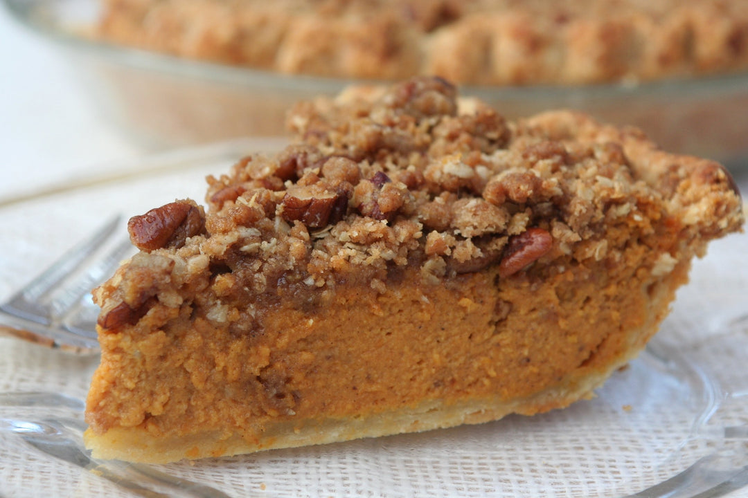 pecan streusel pumpkin pie on a glass plate