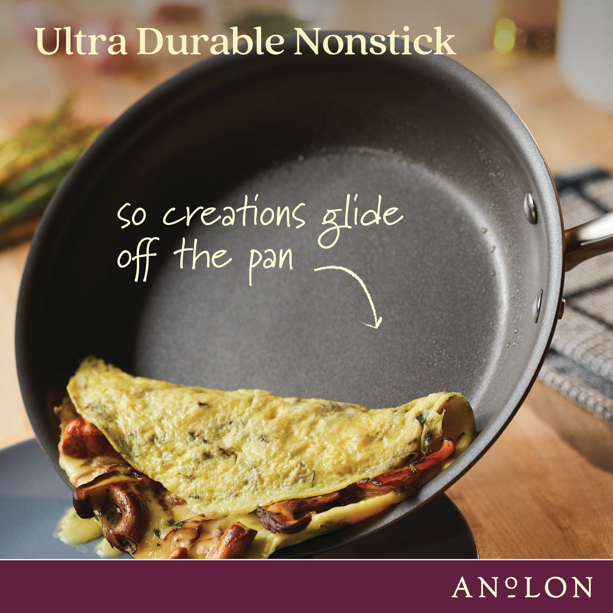 A nonstick frying pan with an omelet sliding off its surface. The text reads Ultra Durable Nonstick and so creations glide off the pan. The pan rests on a wooden surface, and its handle is visible.