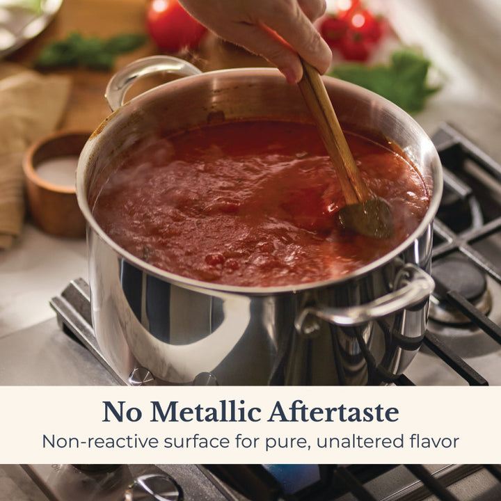 A hand stirs tomato sauce in an EverLast Tri-Ply Clad Stainless Steel 8-Quart Stockpot with Lid on the stove. Text: No metallic aftertaste—non-reactive surface preserves pure, unaltered flavor.