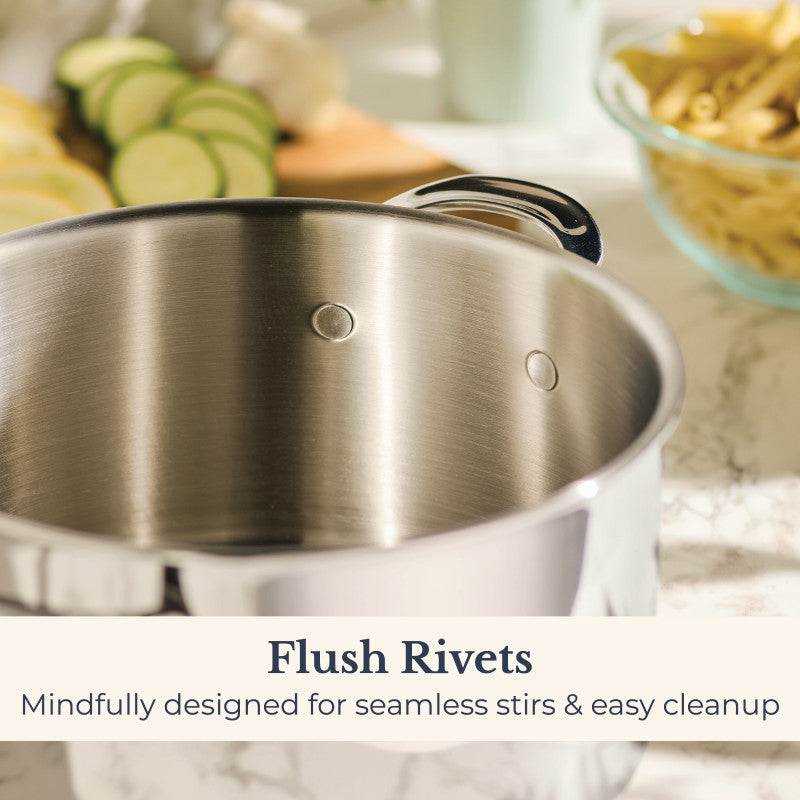 A close-up of the EverLast Tri-Ply Clad Stainless Steel 8-Quart Stockpot with Lid shows flush rivets on its inner wall. Blurred sliced vegetables and pasta appear in the background. Text reads: Flush Rivets—Seamless stirs & easy cleanup.
