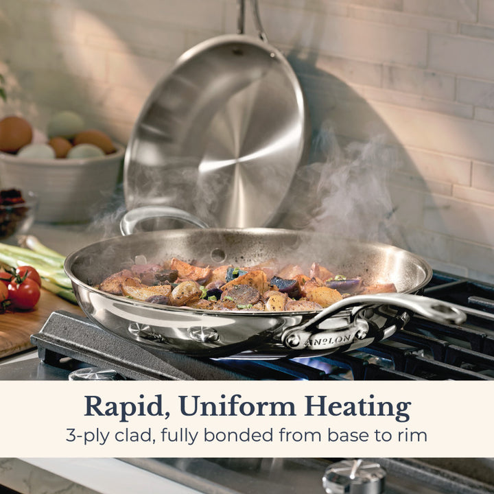 A stainless steel frying pan from the EverLast Tri-Ply Clad Stainless Steel Frying Pan Set cooks food on a stovetop, steam rising. The lid stands upright behind it. Text: Rapid, Uniform Heating. Fully bonded tri-ply construction from base to rim.