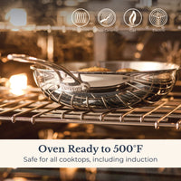 An EverLast Tri-Ply Clad Stainless Steel 12.25-Inch Stir Fry with Helper Handle sits on an oven rack with its lid, safe for induction, glass-ceramic, gas, and electric cooktops. Oven ready to 500°F—ideal cookware for every home chef.