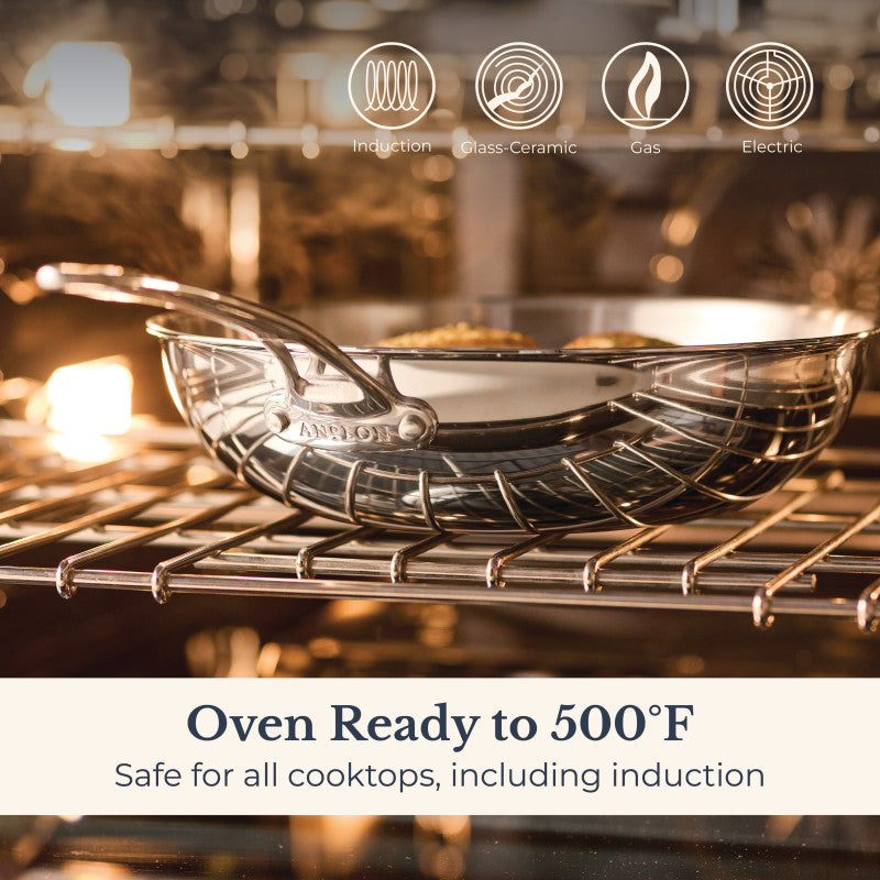 An EverLast Tri-Ply Clad Stainless Steel 12.25-Inch Stir Fry with Helper Handle sits on an oven rack with its lid, safe for induction, glass-ceramic, gas, and electric cooktops. Oven ready to 500°F—ideal cookware for every home chef.