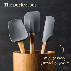 A 3-Piece Spatula Set from Tools and Gadgets, showcasing sophisticated gray silicone heads paired with elegant teak handles, neatly arranged in a bamboo holder. Text at the top says "The perfect set," while "mix, scrape, spread & serve" is written at the bottom accompanied by an arrow pointing to the spatulas.