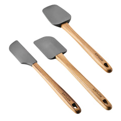 Arranged on a white background, the 3-Piece Spatula Set from Tools and Gadgets showcases three spatulas featuring sleek dark gray silicone heads and elegant teak handles. The brand's subtle inscription near the base adds a touch of sophistication to their design.