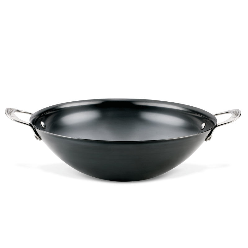 The N2 Carbon Steel Wok by N2 Carbon Steel features a black carbon steel body, a durable nonstick patina, and two stainless steel handles, shown against a white background.