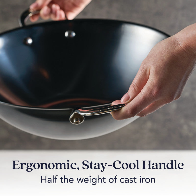 A person holds the N2 Carbon Steel Wok by N2 Carbon Steel, featuring a shiny, ergonomic stay-cool handle. Half the weight of cast iron, this cookware delivers a natural nonstick patina for superior cooking performance.