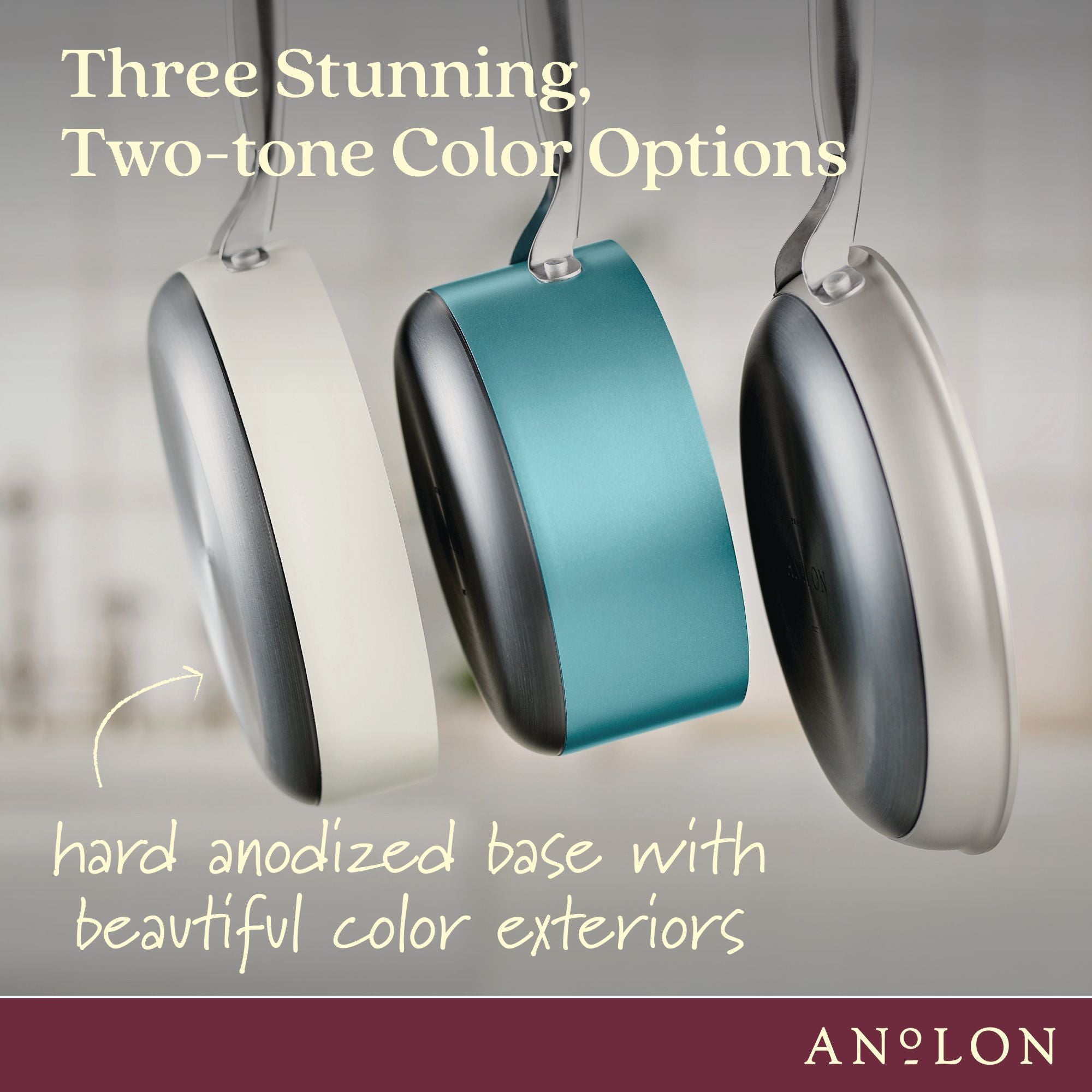 Three frying pans with hard-anodized bases hang side by side, showcasing different color exteriors: white, teal, and gray. Text reads Three Stunning, Two-tone Color Options and hard anodized base with beautiful color exteriors. Anolon logo at the bottom.
