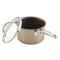 A medium-sized, nonstick saucepan with a glass lid and a stainless steel handle, placed on a white background. The body of the pan is beige, and the handle is engraved with the brand name ANOLON.