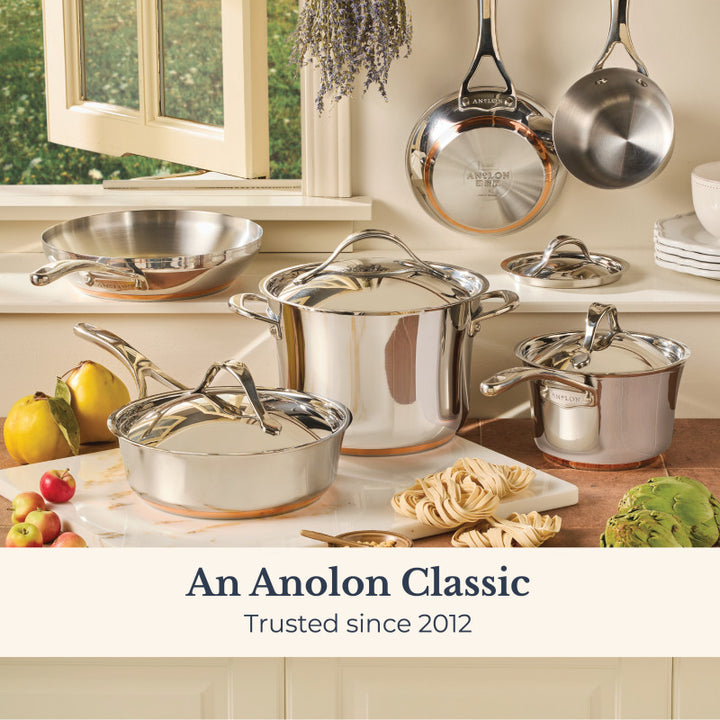 A gleaming Nouvelle Stainless 2.5-Quart Saucier with Lid sits on the kitchen counter among fresh fruits, veggies, and pasta. The text reads “A Nouvelle Stainless Classic - Trusted since 2012.” Enjoy optimum heat control every meal.