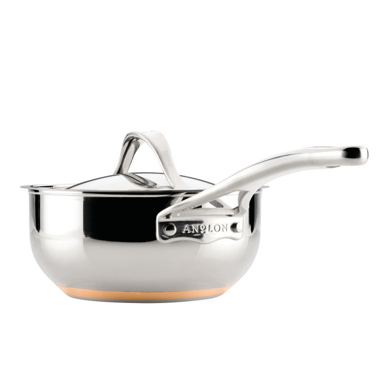 A shiny 2.5-Quart Saucier with Lid from Nouvelle Stainless, featuring a long handle engraved with the brand name and a copper-colored base for optimum heat control.