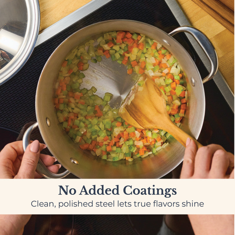 A person stirs chopped carrots, celery, and onions in a Nouvelle Stainless 6.5-Quart Stockpot with Lid using a wooden spoon. Text reads: No Added Coatings. Clean, polished steel lets true flavors shine.
