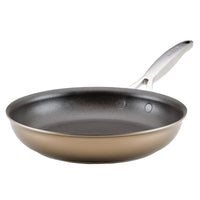 A non-stick frying pan with a metallic handle, shown from a side angle on a white background. The pan has a sleek, dark interior surface and a shiny, light brown exterior.