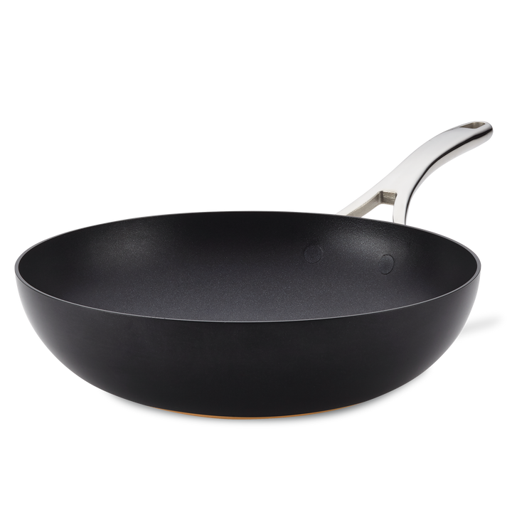 The Nouvelle Copper Luxe 12-Inch Stir Fry pan features a nonstick black surface, wide base, silver metal handle, and is induction suitable, shown on a plain white background.