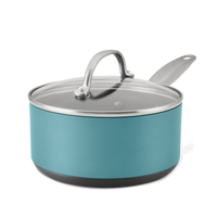 A teal saucepan with a glass lid and silver handle is isolated against a white background. The saucepan has a smooth finish and a sturdy, flat base.