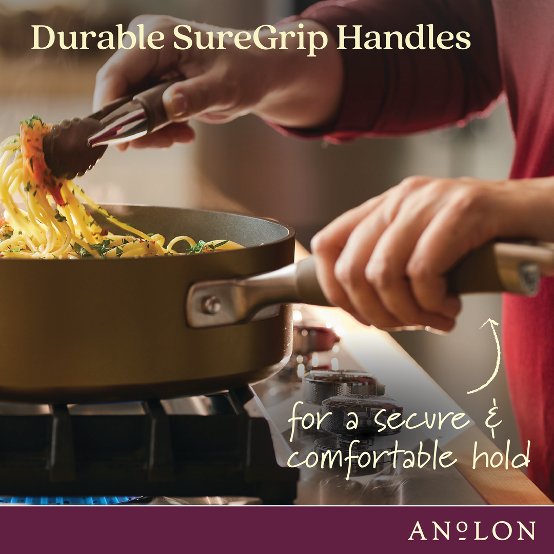 A person in a red sweater is using tongs to serve pasta from the Round Two Step Meal Set on the stovetop. The focus is on the pot's ergonomic handle. Text reads: Durable SureGrip Handles for a secure & comfortable hold. Advanced Home logo at the bottom, showcasing their hard-anodized nonstick cookware.