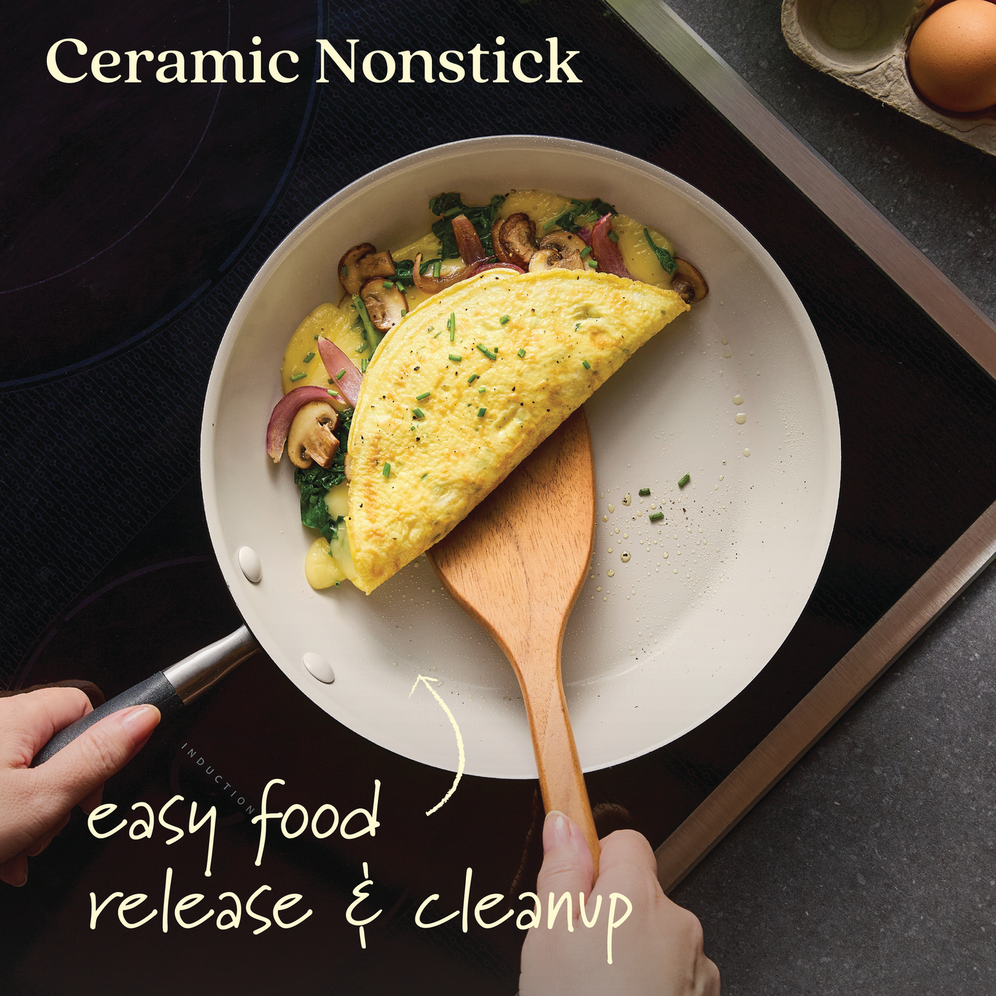 A person skillfully uses a wooden spatula to lift a mushroom and greens omelette from an Advanced Ceramic pan, part of the 10-Piece Ceramic Nonstick Cookware Set, known for easy food release and cleanup. An egg carton and heated element are visible in the background.