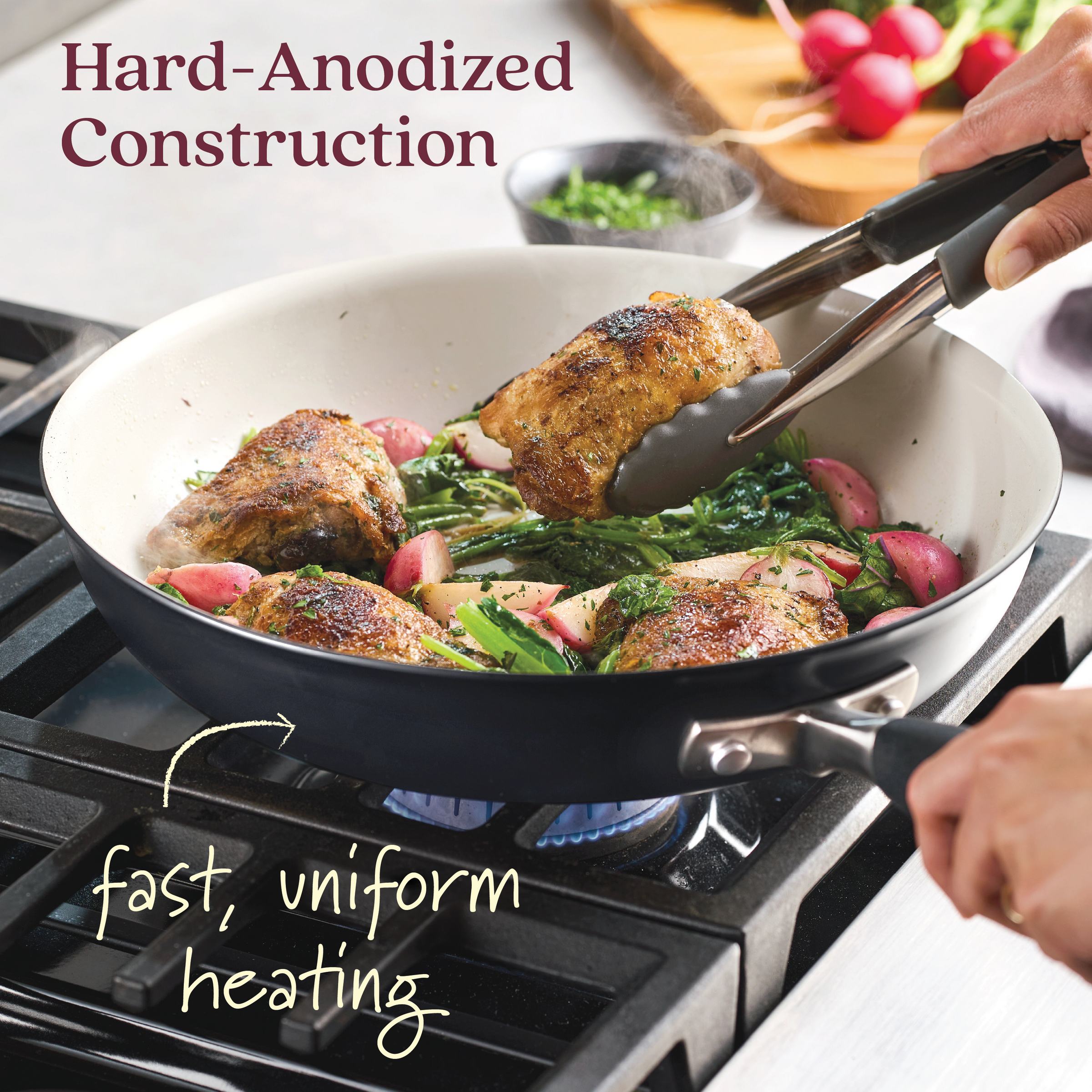 An Advanced Ceramic 12-inch nonstick frying pan rests on a gas stove, with tongs lifting cooked chicken over leafy greens and radishes. Text reads Hard-Anodized Construction and fast, uniform heating, highlighting premium cookware quality.