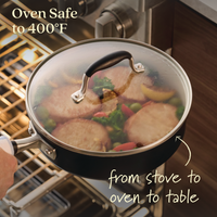 Using the Advanced Ceramic 10-Piece Nonstick Cookware Set, a person places a lidded skillet with cooked meat and veggies into an oven. The lid features a handle, showcasing its Oven Safe to 400°F versatility from stove to oven to table.