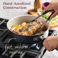 A person turns a rolled roast in the 10-Piece Ceramic Nonstick Cookware Set by Advanced Ceramic on a gas stove using tongs. The hard-anodized cookware with potatoes and herbs ensures fast, uniform heating. Text reads Hard-Anodized Construction.