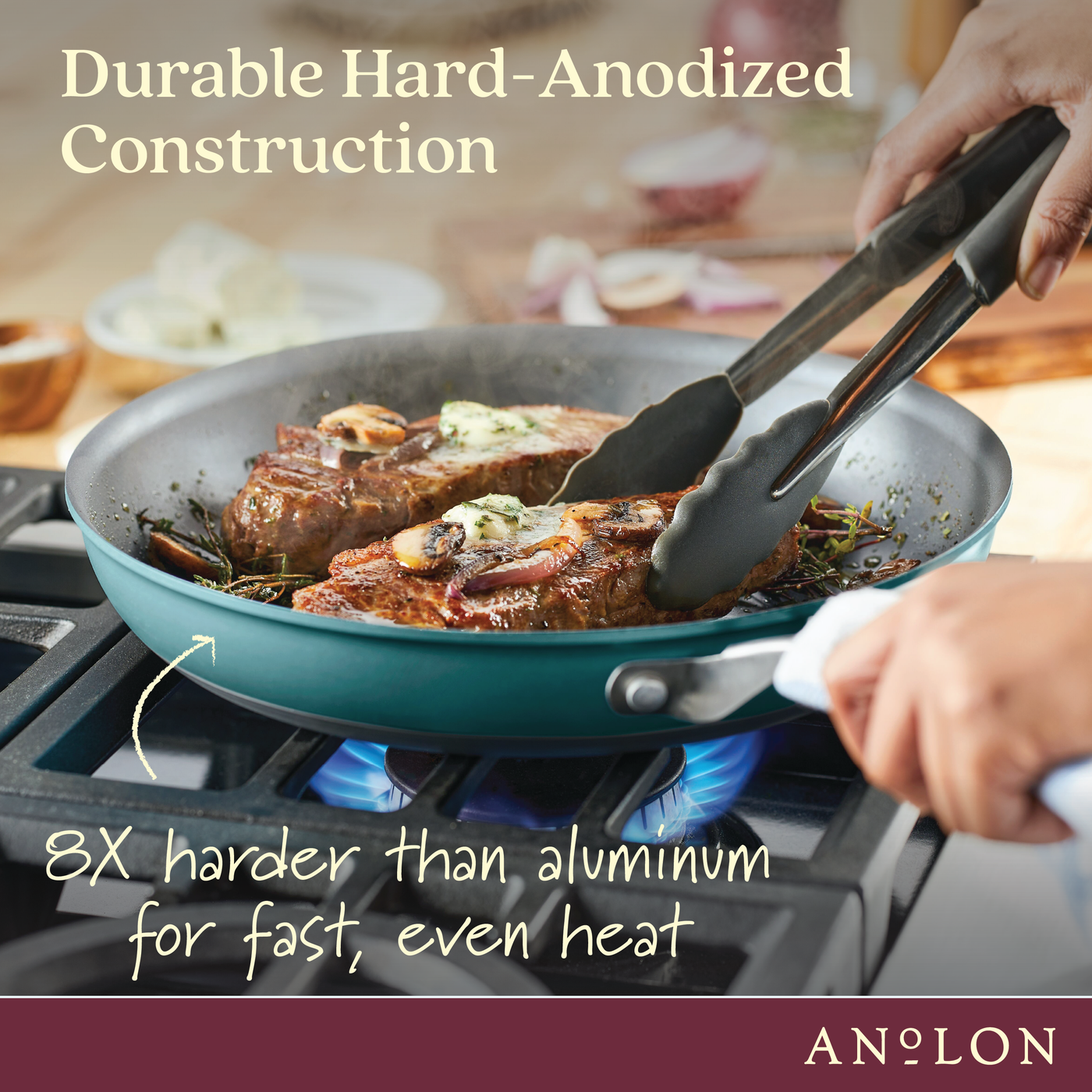 A person cooks steak with mushrooms in a turquoise pan on a blue flame stove. Text reads Durable Hard-Anodized Construction and 8X harder than aluminum for fast, even heat. Brand name Anolon is displayed at the bottom.