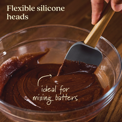 A hand is shown mixing chocolate batter in a glass bowl with a spatula from the Tools and Gadgets 3-Piece Spatula Set, featuring a flexible silicone head and teak handle. The text states, "Flexible silicone heads, ideal for mixing batters.