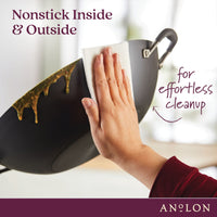 A hand wipes a nonstick wok with a paper towel. The wok is shown with curry residue, highlighting easy cleanup. Text reads: Nonstick Inside & Outside for effortless cleanup. The brand name Anolon is displayed in the corner.