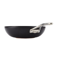 The Nouvelle Copper Luxe 12-Inch Stir Fry pan features a black nonstick finish, a silver handle engraved with ANOLON, and is induction suitable. Shown in side view against a white background.