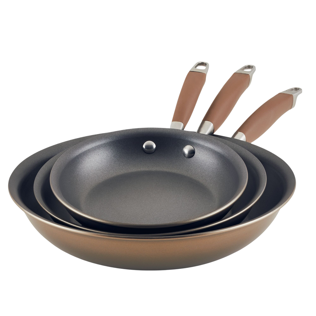 Three frying pans of different sizes from the Advanced Home 3-Piece Nonstick Frying Pan Set are stacked together. They feature brown handles with metal ends, ideal for hanging. The pans have a sleek, black cooking surface that provides hard-anodized durability.