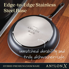 An item from The Everything Set: 75 Pieces by Exclusive is set on a wooden surface. This round, dark-colored pan comes with a glossy silver Edge-to-Edge Stainless Steel Base, part of the Anolon X kitchen collection. It includes SearTech™ technology for superior durability and is fully dishwasher-safe, with branding that reads Anolon X.