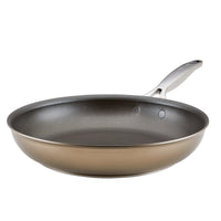 A non-stick frying pan with a metallic handle, shown against a plain white background. The pan has a smooth, dark interior and a shiny exterior.