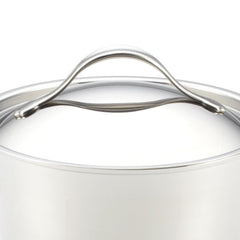 Crafted from polished stainless steel, this induction-ready pot lid showcases a graceful curved handle on top and is artfully presented from a side angle against a simple white background. Ideal for those passionate about gourmet cooking, part of the Nouvelle Stainless 12-Piece Cookware Set.