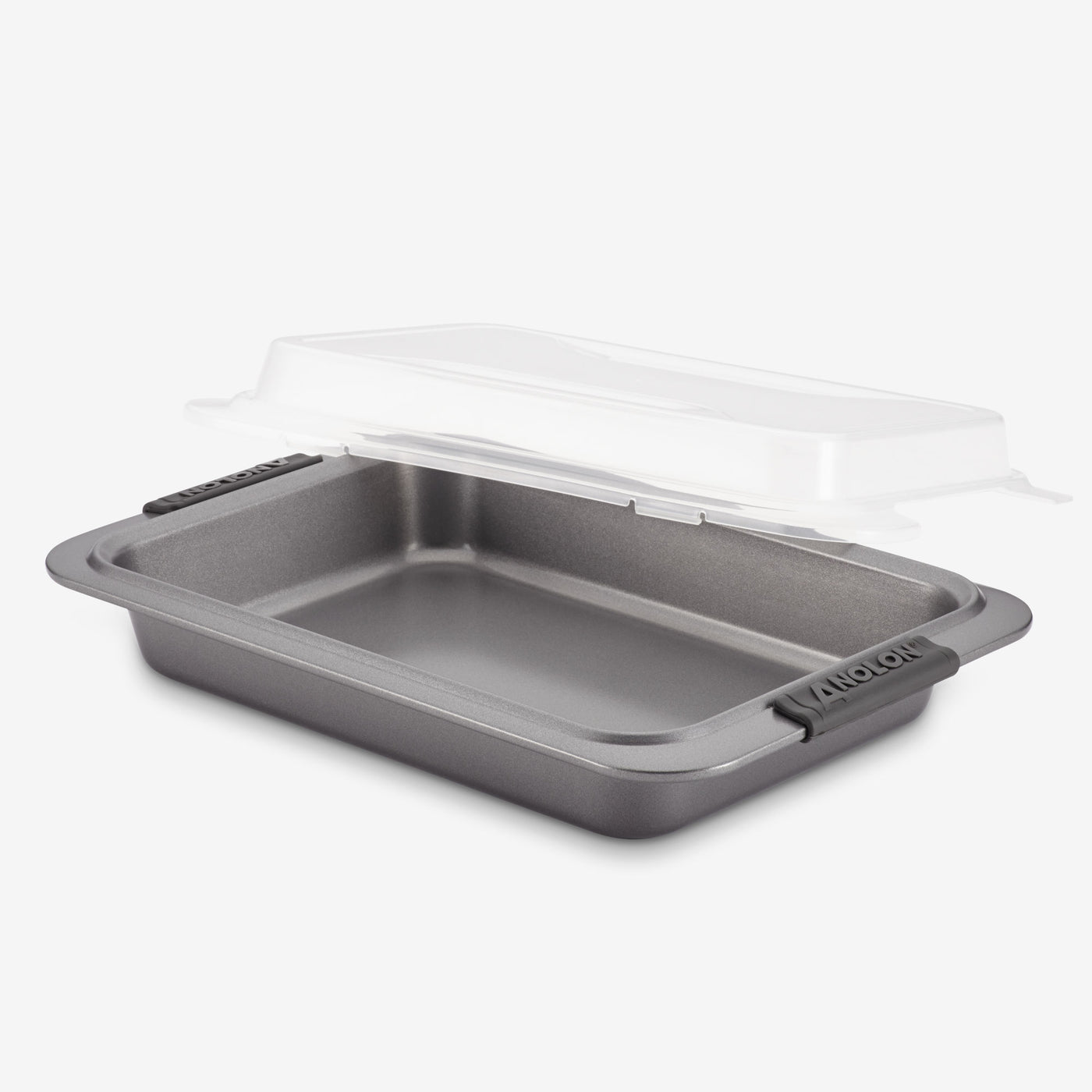A rectangular non-stick baking pan with handles, featuring a transparent plastic lid slightly lifted above it. The lid is designed to securely cover the pan, providing convenience for storage or transport.