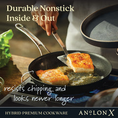 A person is preparing fish fillets in a frying pan on the stove, highlighting AnolonX's 7-Piece Hybrid Nonstick Cookware Set. This set features a durable nonstick finish that resists chipping and includes SearTech technology, ensuring perfect searing every time, paired with fresh greens.