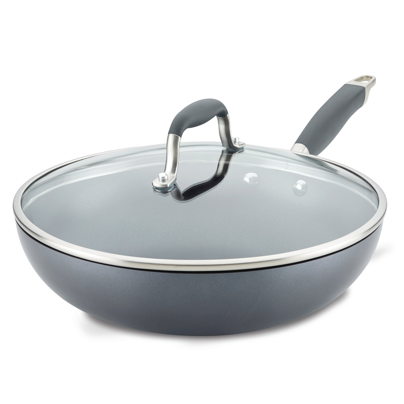 A gray non-stick frying pan with a clear glass lid and a black handle is shown. The lid has a metallic rim and handle. The pan is slightly angled, showcasing its deep design and shiny finish.