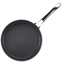 An overhead view shows a black Anolon X 3.5-Quart Hybrid Nonstick Induction Sauté Pan with Lid, featuring SearTech technology and a grid-like cooking surface. Its shiny metal handle has a hole for hanging, and its oven safe up to 500°F.