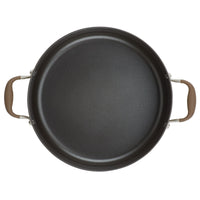 A top view of a non-stick frying pan with two brown handles, placed against a white background. The pan has a dark interior surface.
