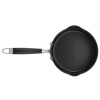 A black nonstick saucepan with a long handle and a metal loop for hanging, viewed from above.