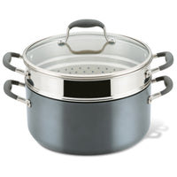A two-tier steamer pot with a glass lid, featuring gray handles. The bottom pot is solid, while the top tier is a metal steamer insert with perforations, designed for steaming food.