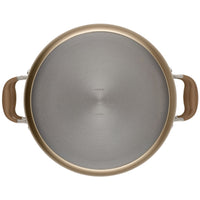 A top view of a round, stainless steel pot with tan handles on either side. The pot has a metallic finish and appears clean and unused, placed against a plain white background.