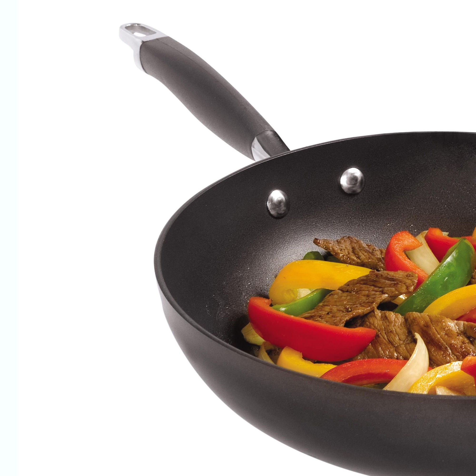 A black frying pan containing stir-fried beef strips and colorful bell peppers, including red, yellow, and green slices, against a white background. The pan has a long handle for easy gripping.