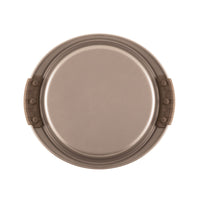 A round, beige baking pan with two dark brown silicone grips on opposite sides, viewed from above. The pan has a sleek, non-stick surface and a raised edge.