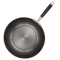 A top view of a black non-stick frying pan with a silver base and a black handle. The pan is placed against a white background.