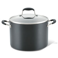 A large black pot with a glass lid and metal handles, featuring rubber grips. The pot is cylindrical with a smooth surface and a matte finish.