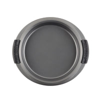 A gray, round baking pan with black, rubberized handles on each side. The surface has a non-stick coating and is seen from above, showcasing its smooth interior and sturdy construction.