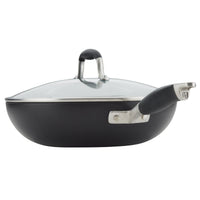 A black nonstick skillet with a glass lid and a sturdy black handle, positioned on a white background. The lid has a stainless steel rim and a matching black and silver handle.