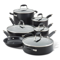 A set of black non-stick cookware, including various pots and pans with glass lids and metal handles, arranged in a group. The set features multiple sizes suitable for different cooking needs.